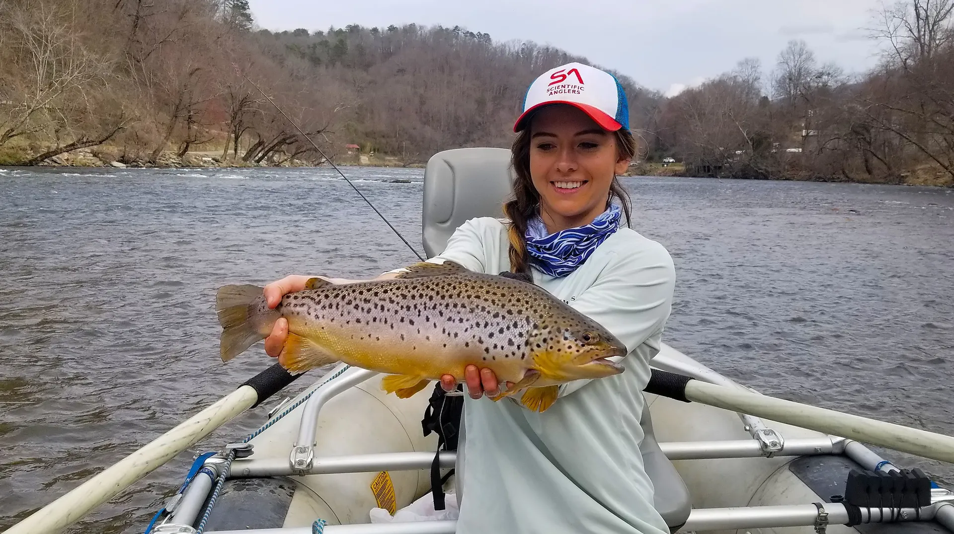 Angler holding a brown trout — skills development for recreational anglers